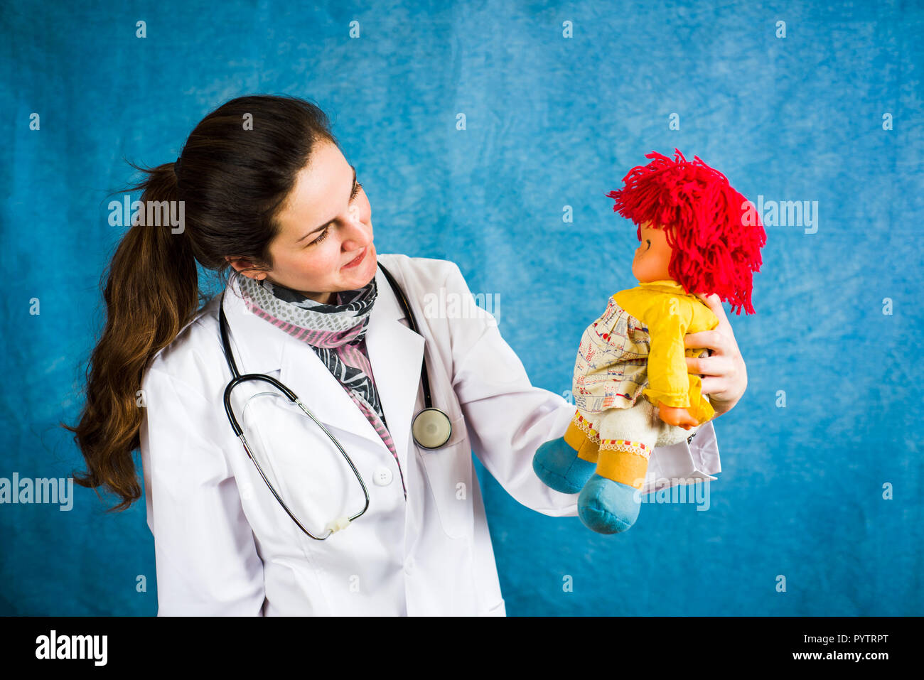 Female doctor holding a cheerful baby doll Stock Photo