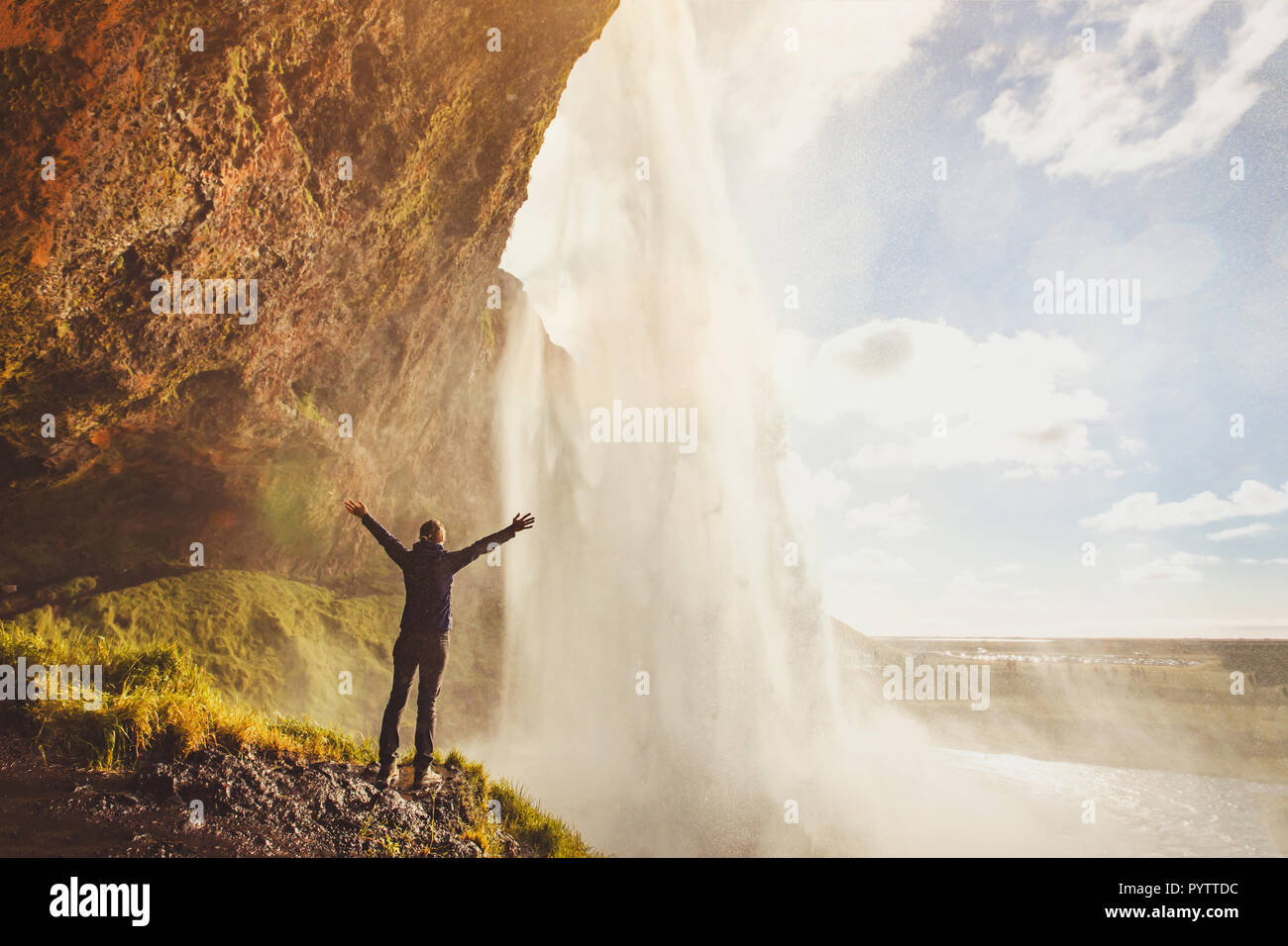 inspiring travel landscape, person standing near beautiful waterfall in Iceland Stock Photo
