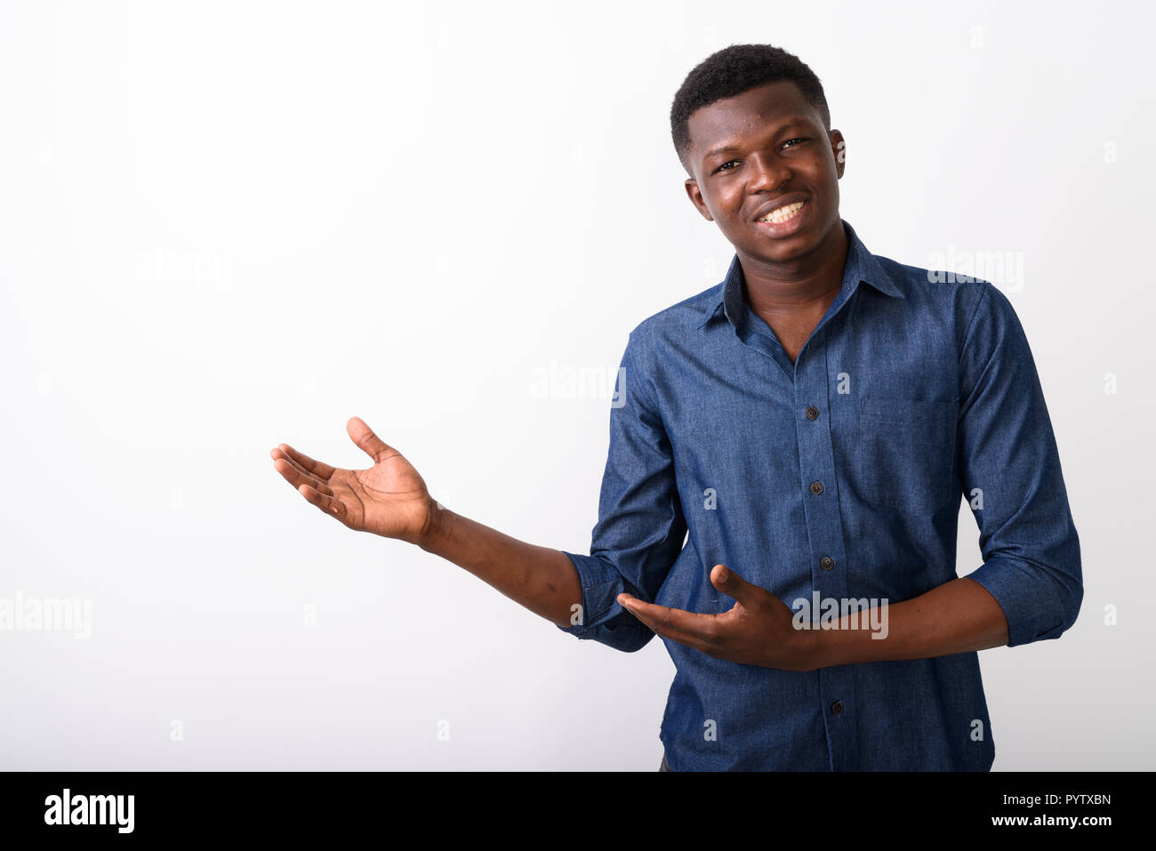 Studio shot of young happy black African man smiling while showi Stock Photo