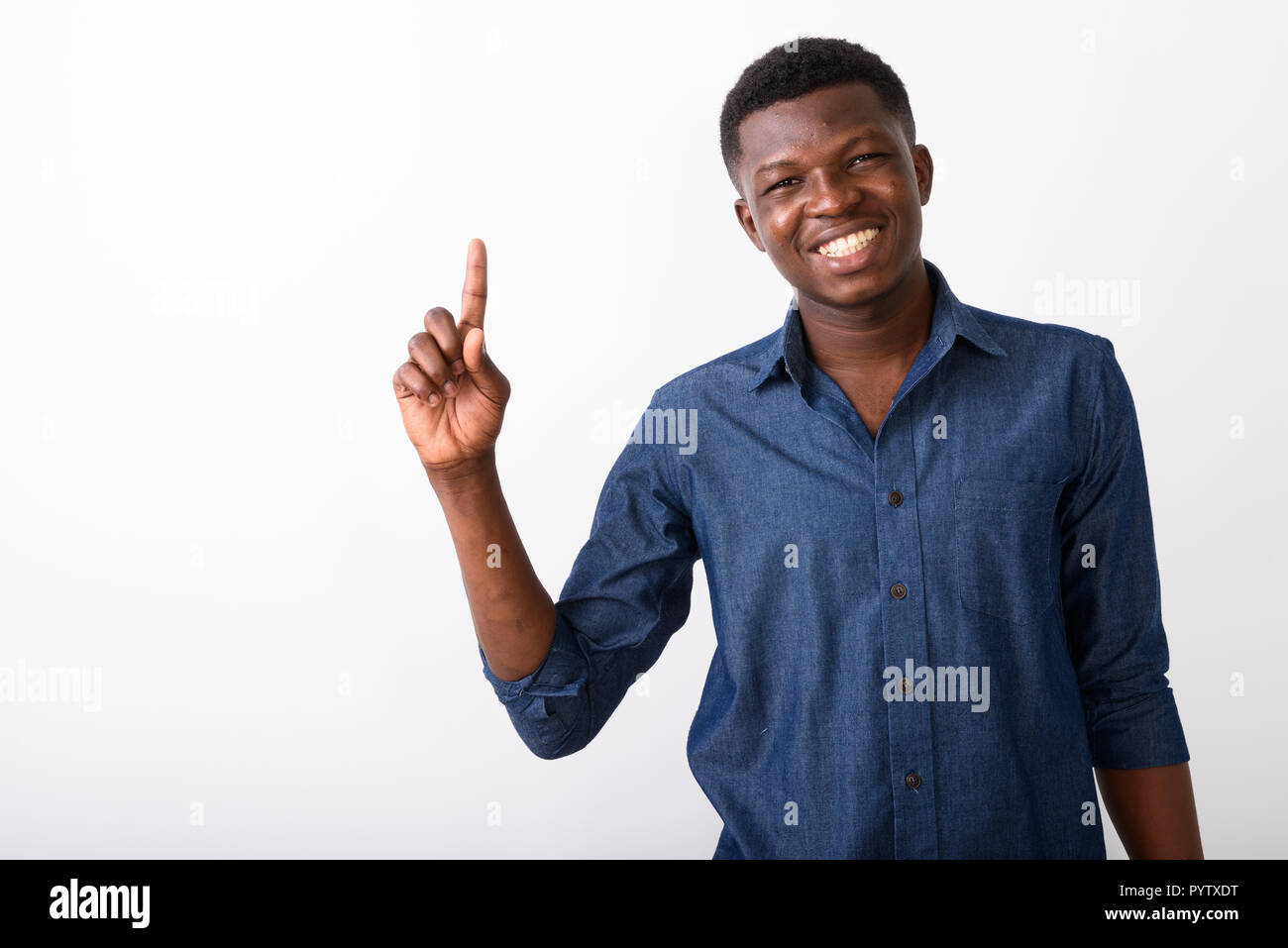Studio shot of young happy black African man smiling while point Stock Photo