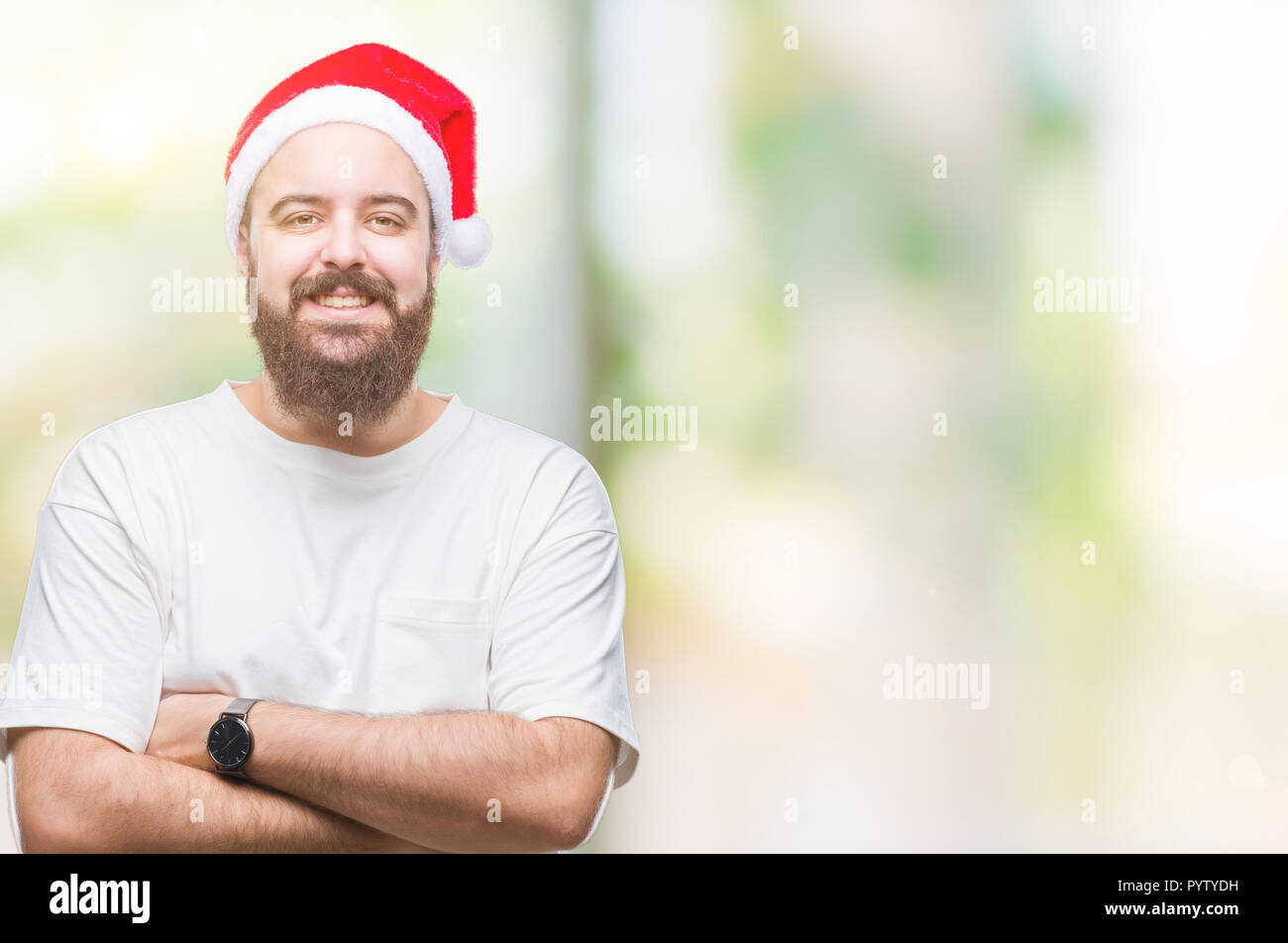 Young caucasian hipster man wearing christmas hat over isolated background happy face smiling with crossed arms looking at the camera. Positive person Stock Photo