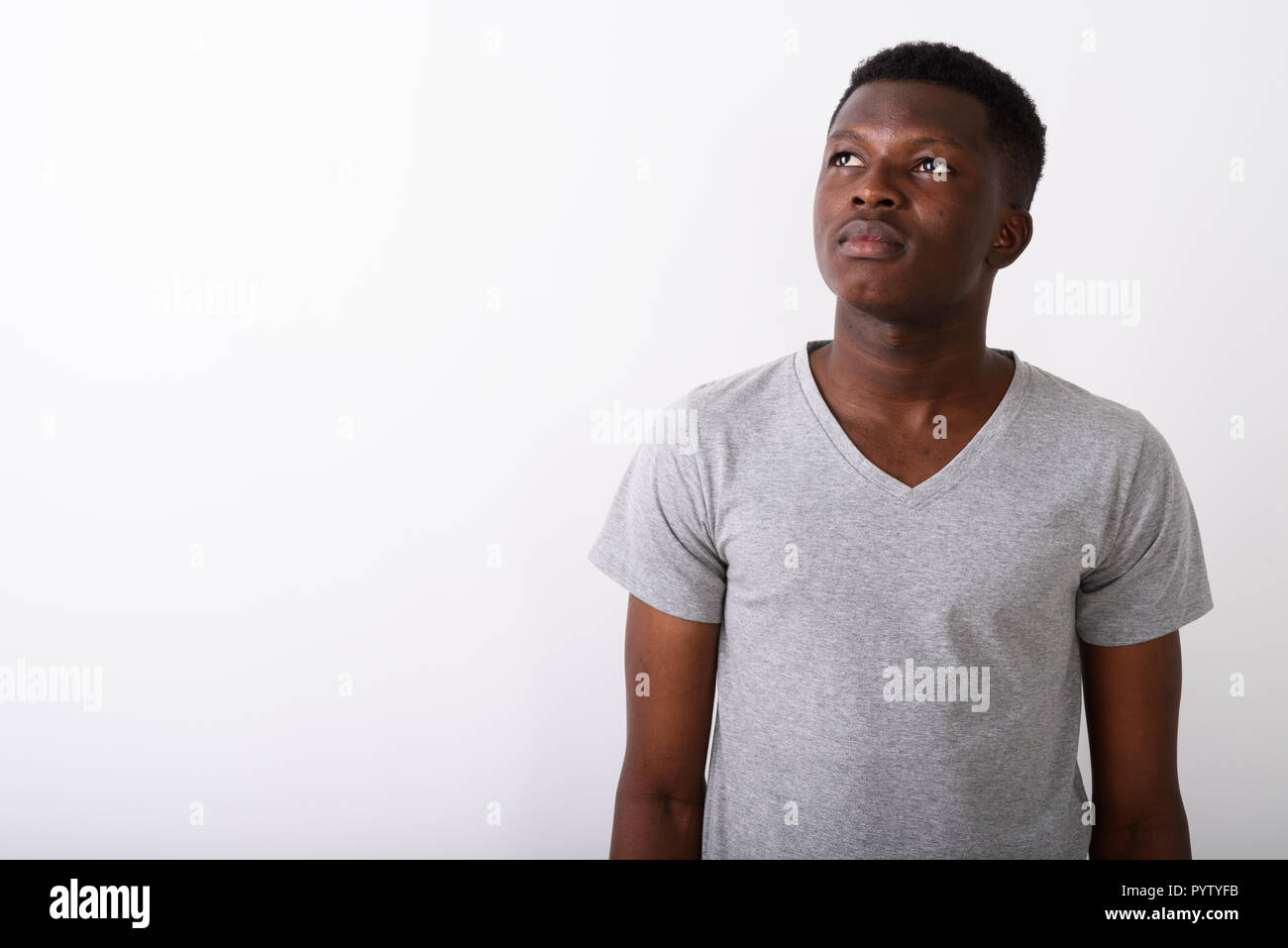 Studio shot of young black African man thinking while looking up Stock ...