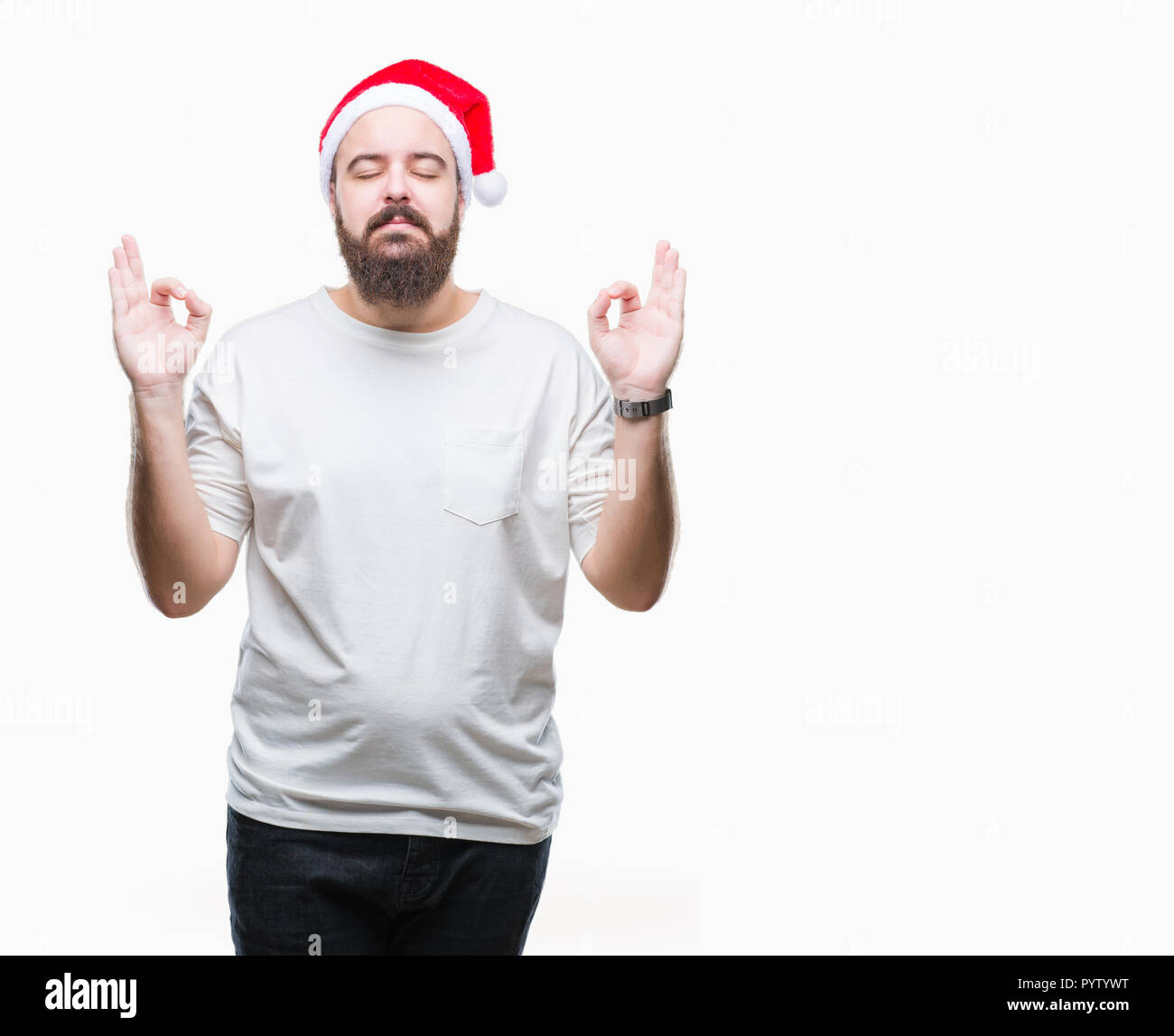 Young caucasian hipster man wearing christmas hat over isolated background relax and smiling with eyes closed doing meditation gesture with fingers. Y Stock Photo