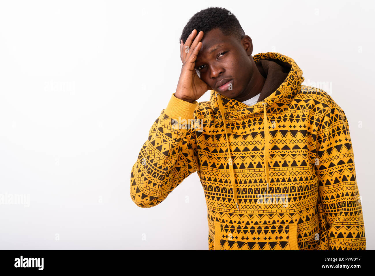 Studio shot of young black African man having headache against w Stock Photo