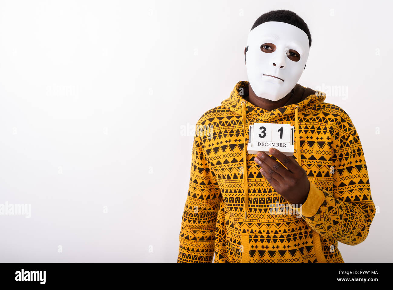 Studio shot of young black African man wearing white mask while  Stock Photo