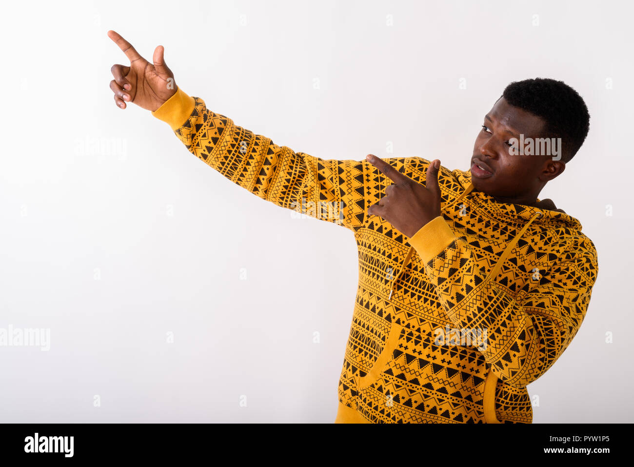 Studio shot of young black African man pointing both fingers up  Stock Photo