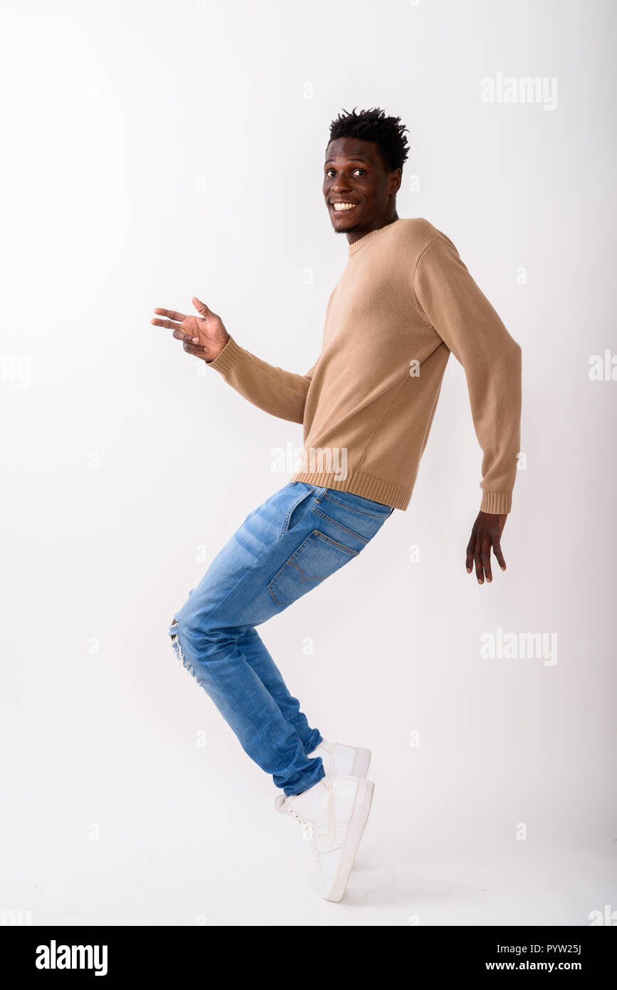 Full body shot of young happy black African man smiling while po Stock Photo