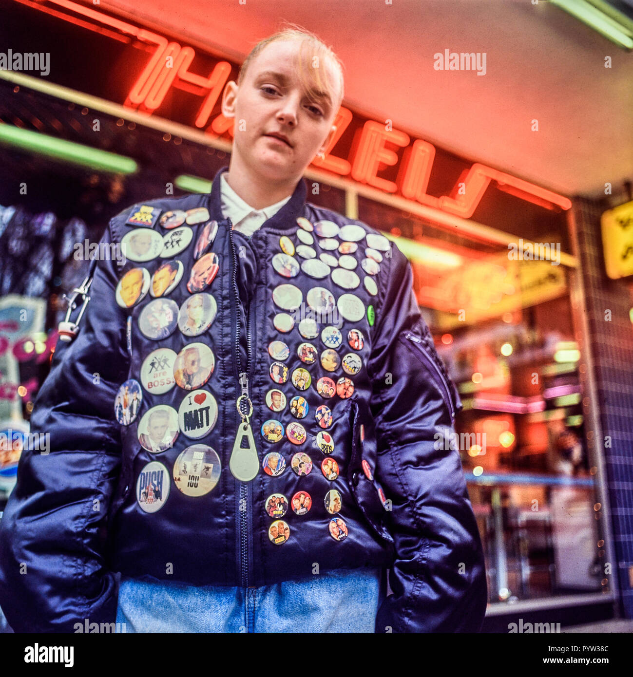 Manchester, England, Uk January 1989: A young girl poses outside a record shop with her many Bros boy band badges. Stock Photo