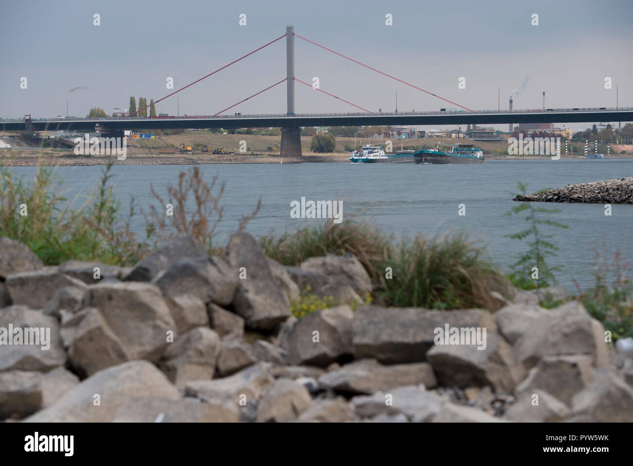 Leverkusen, Deutschland. 30th Oct, 2018. Cargo ships on the Rhine, in the background the Leverkusen Bridge and the Bayer plant, Chempark, in the foreground a gravel bank, low water in the Rhine, the low water level allows cargo ships to drive only with less cargo, | usage worldwide Credit: dpa/Alamy Live News Stock Photo