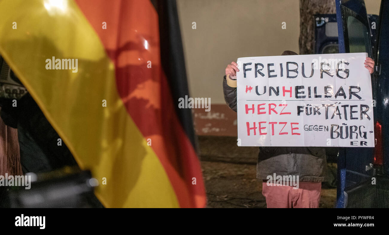 Freiburg, Germany. 29th Oct, 2018. A participant of an AFD rally holds a poster with the inscription 'Freiburg Unheilbar - Herz für Täter, Hetze gegen Bürger'. The AfD called for an assembly, several groups planned a counter-demonstration and a rally to warn against instrumentalizing the crime. Credit: Patrick Seeger/dpa/Alamy Live News Stock Photo