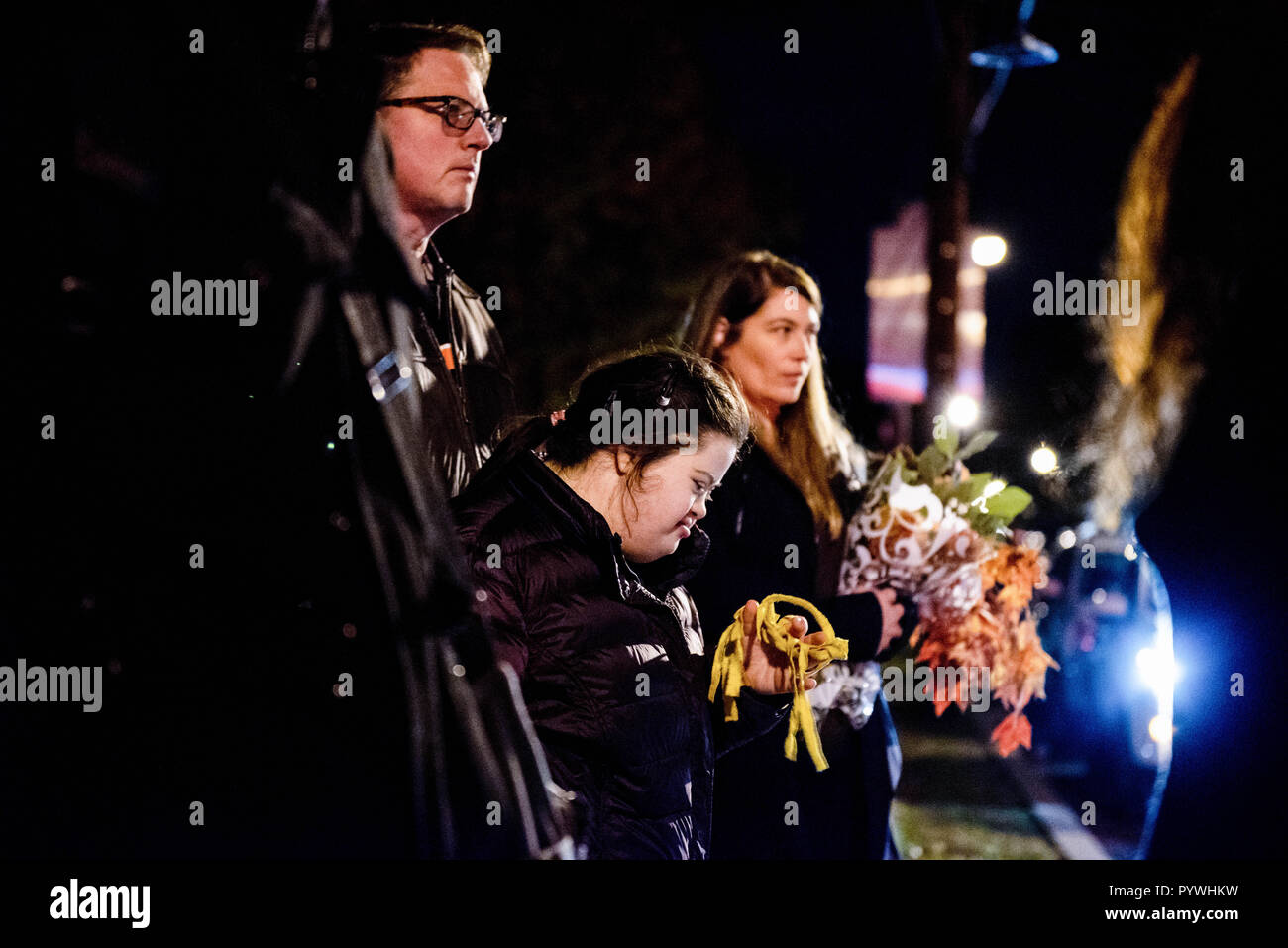 Pittsburgh, USA. 29th Oct, 2018. Differently-abled girl in prayer with caretaker and woman with flowers.After the shooting at the Tree of Life synagogue in Squirrel Hill, Pittsburgh, PA, mourning takes place, with police around, the larger community comes together with music and healing. Credit: Aaron Jackendoff/SOPA Images/ZUMA Wire/Alamy Live News Stock Photo