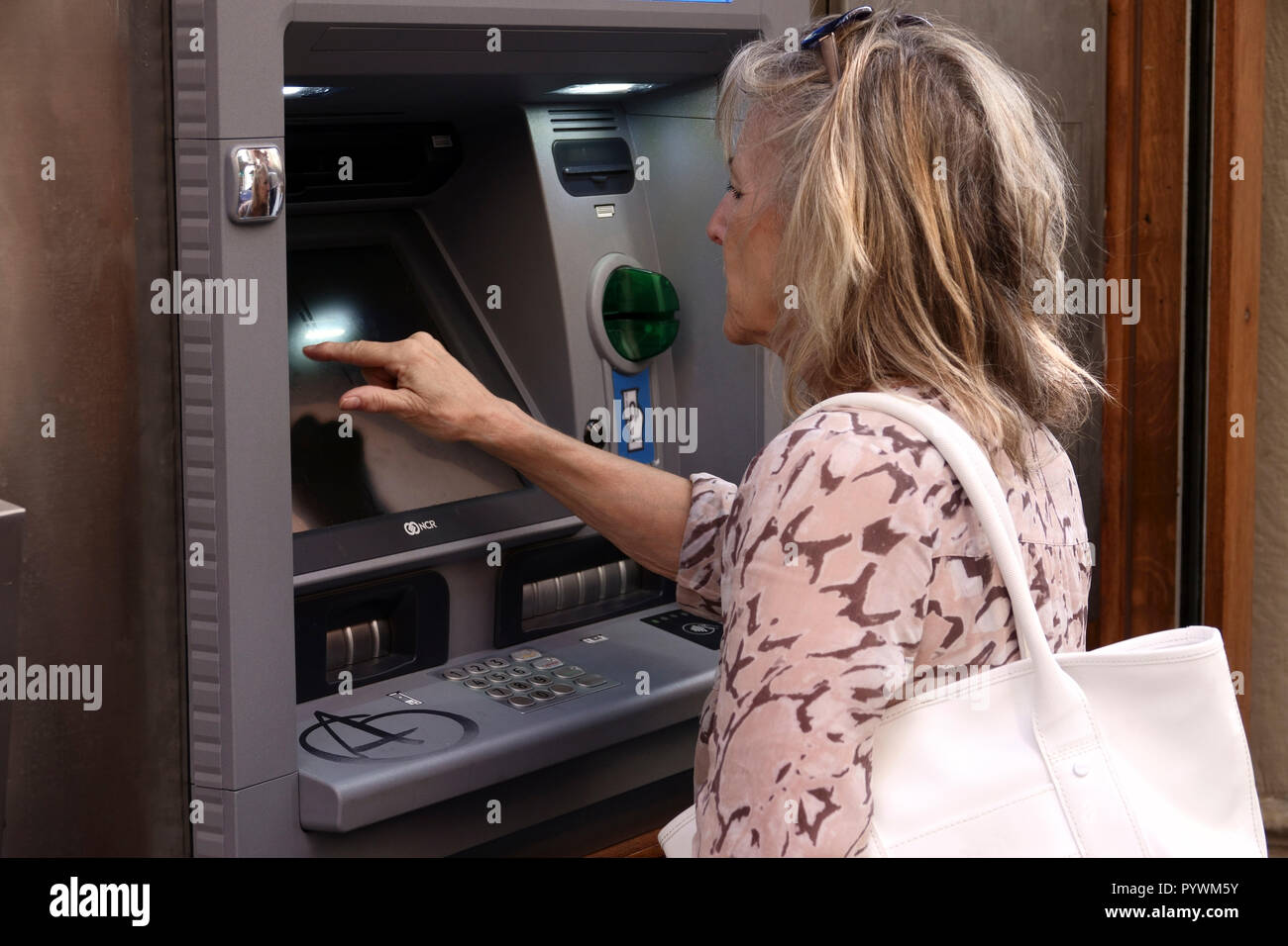 Bilbao City, Basque Region, Spain Woman withdraws Euro's cash from an ATM in old Town Stock Photo