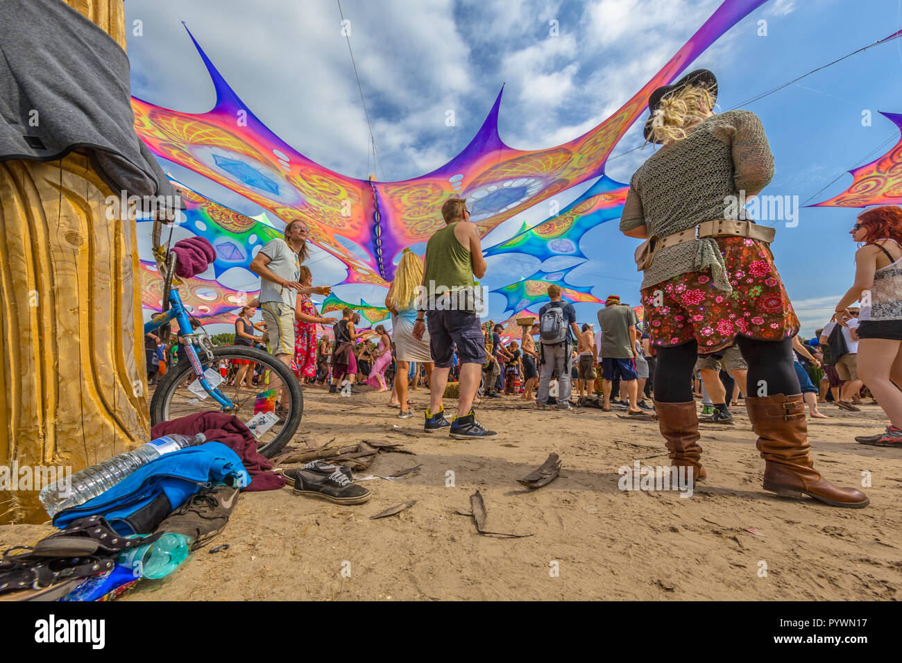 LEEUWARDEN, NETHERLANDS-AUGUST 30, 2015: Decoration, shoes, bicycle and people partying on the sandy dance floor at Psy-Fi open air psychedelic trance Stock Photo