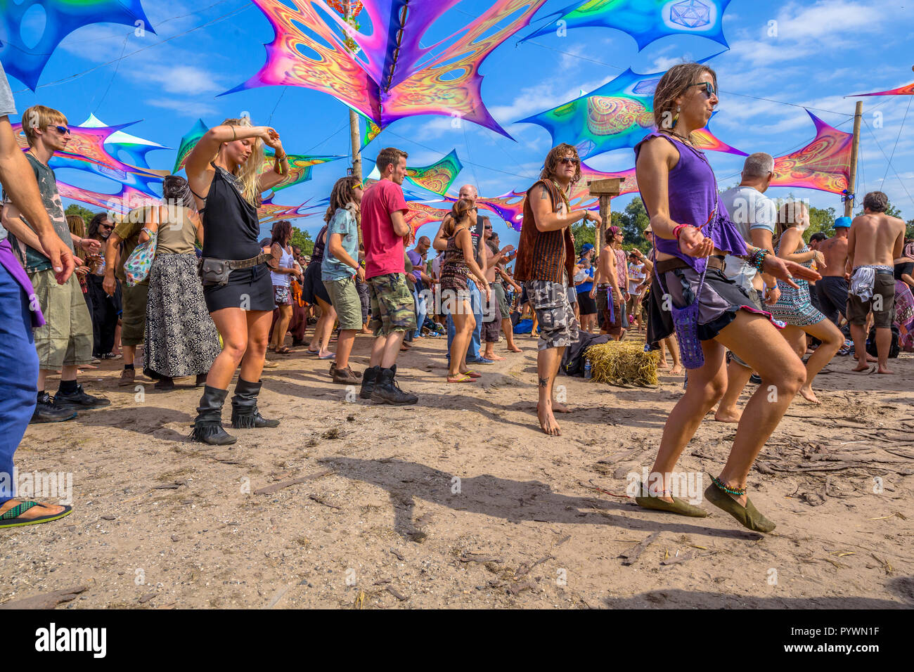 LEEUWARDEN, NETHERLANDS-AUGUST 30, 2015: Colorful party people dancing on the sandy dancefloor during daytime on Psy-Fi open air psychedelic trance mu Stock Photo