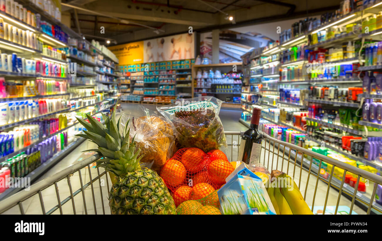 Easter shopping Grocery cart at a colorful supermarket filled up with food products as seen from the customers point of view Stock Photo