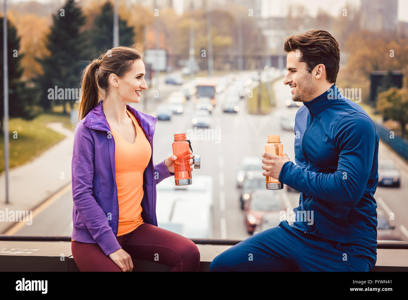 Woman and man drinking water in break from fitness training Stock Photo