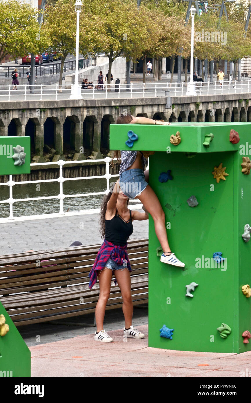 Bilbao City, Basque Region, Spain Young girls messing about on the city's climbing pods Stock Photo