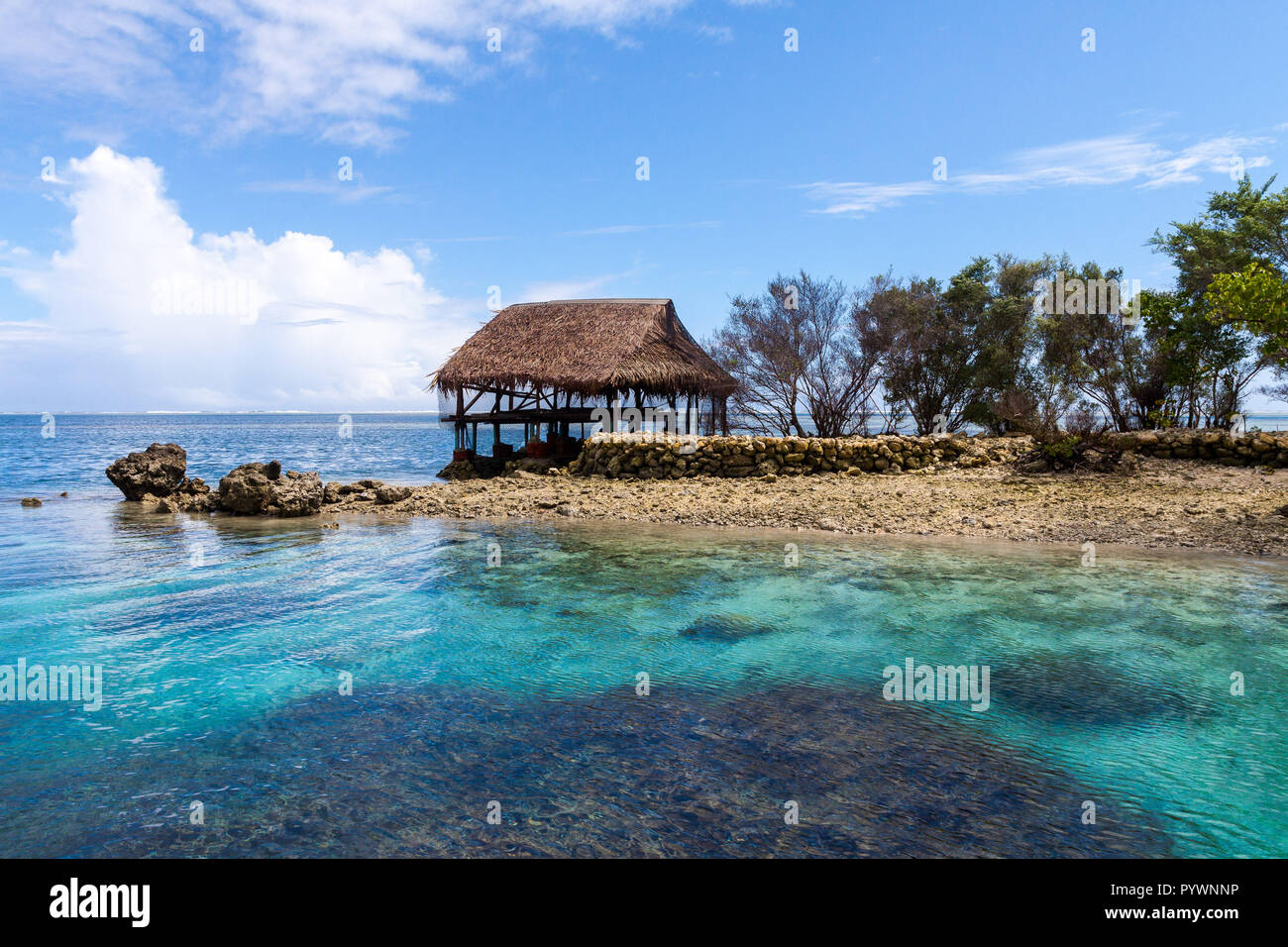 Traditional bungalow of native aborigines Micronesian people. Reef coral island motu. Blue azure turquoise lagoon with corals. Pohnpei island, Micronesia, Federated States of Micronesia (FSM), Oceania Stock Photo