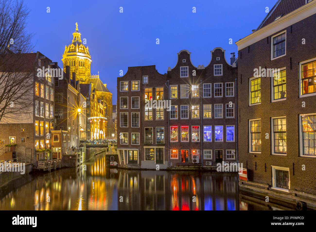 Nightscape of colorful traditional waterfront canal houses at night seen from the armbrug on the Oudezijds Voorburgwal in the UNESCO World Heritage si Stock Photo