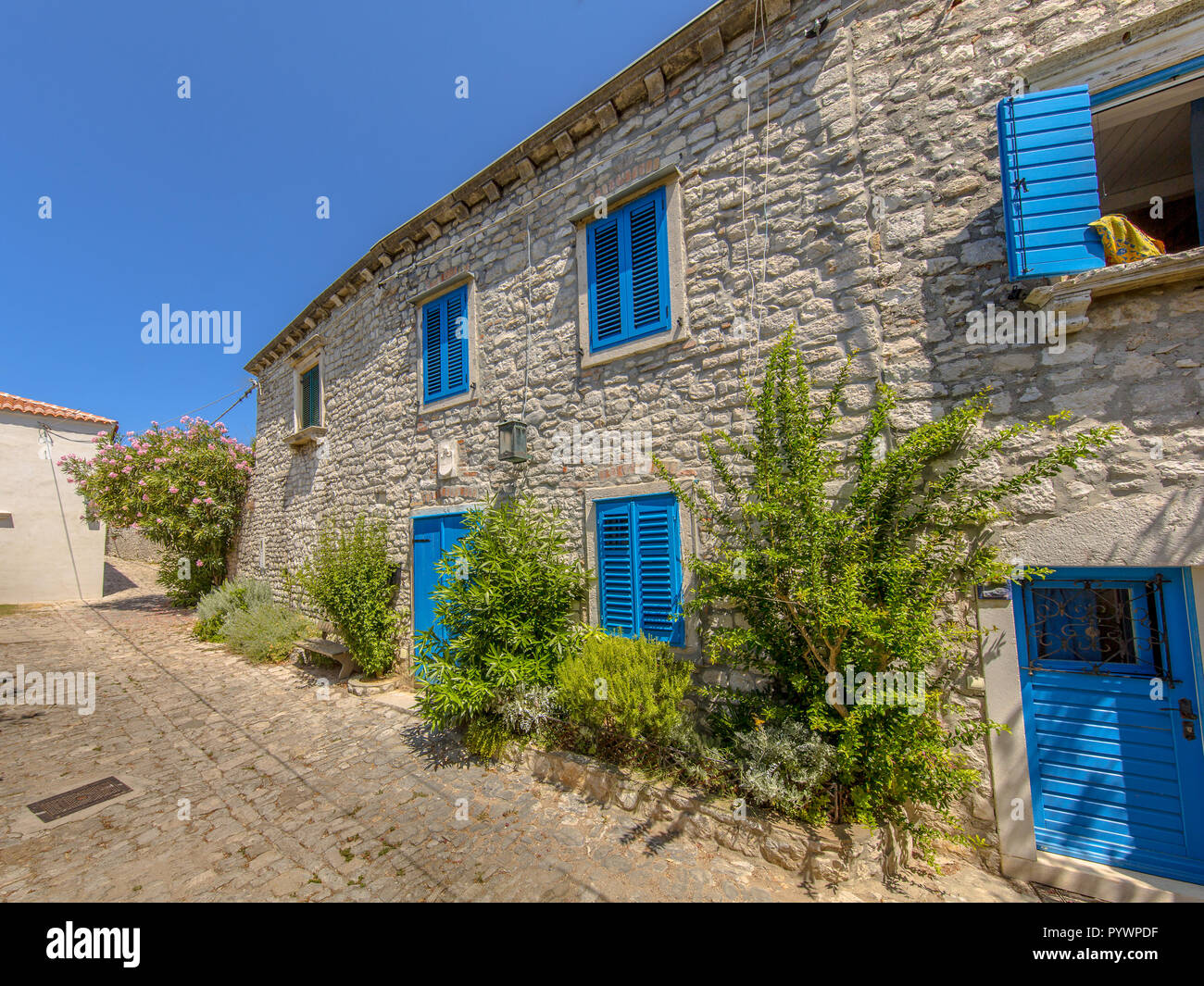 Traditional Croatian apartment complex with blue painted windows in town of Osor on Cres Island, Istria, Croatia, Europe Stock Photo