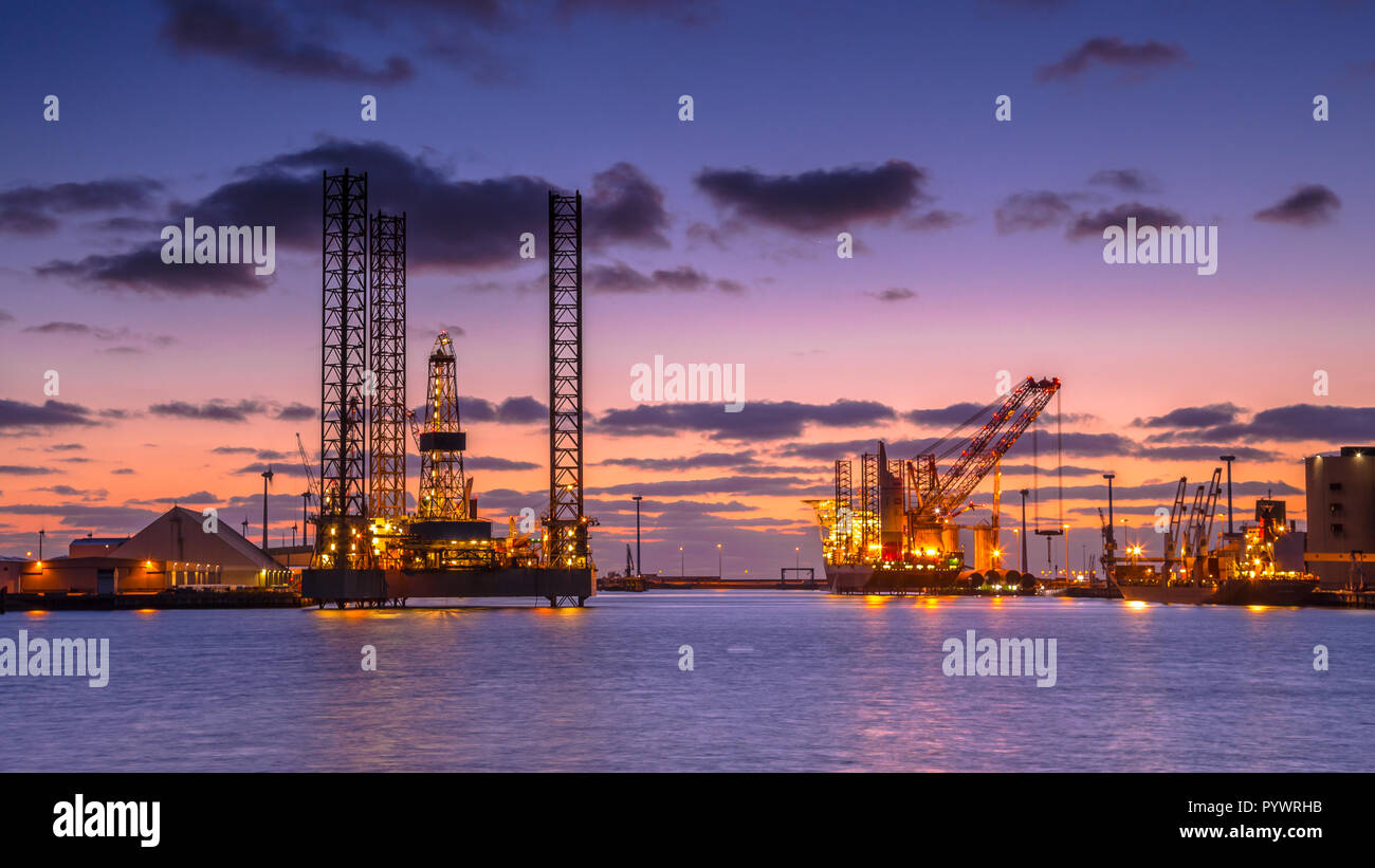 Oil Platforms being built in a harbor under beautiful sunset Stock