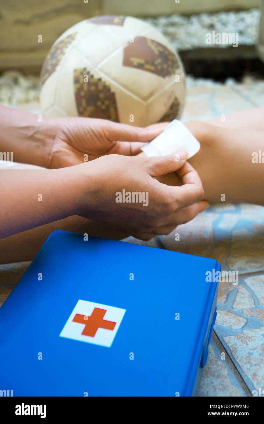 Woman puts adhesive bandage on child knee Stock Photo Alamy