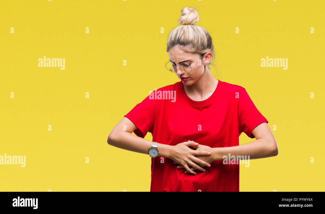 Young beautiful blonde woman wearing red t-shirt and glasses over isolated background with hand on stomach because indigestion, painful illness feelin Stock Photo