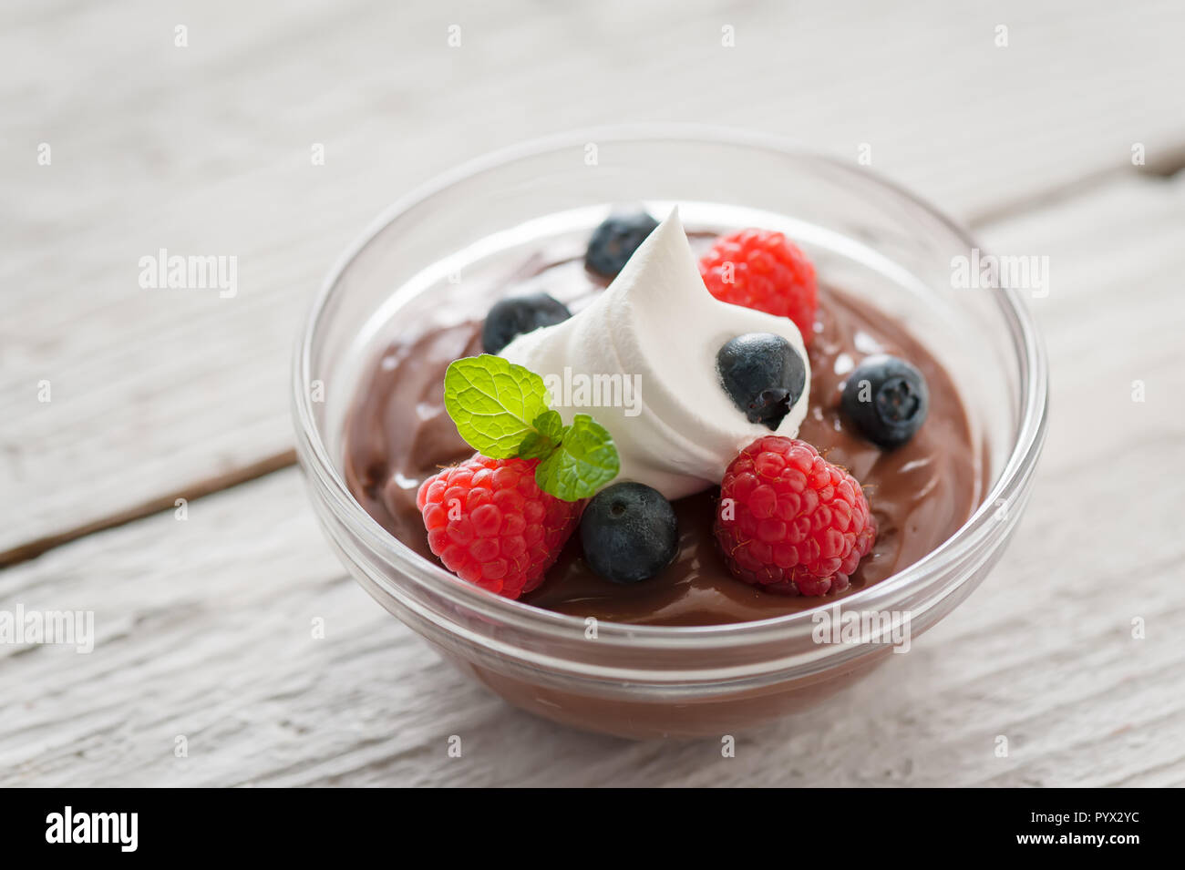 Chocolate pudding berry bowl with dollop of cream. Stock Photo