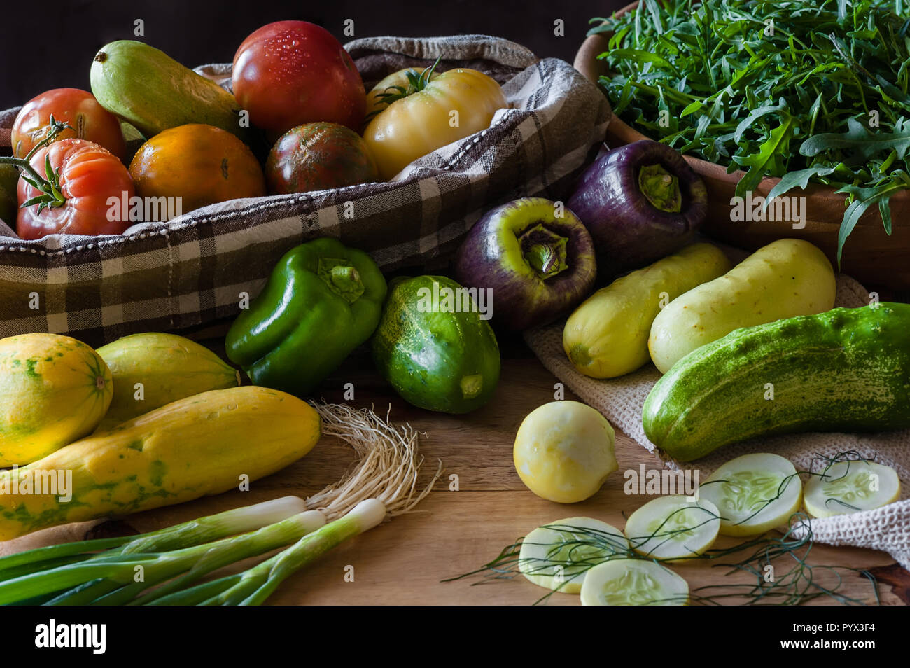 Fresh cucumbers, tomatoes, squash, onions, peppers and arugula. Stock Photo