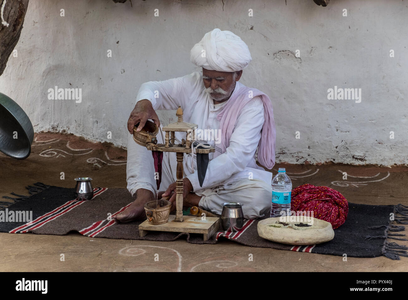 Male elder in a Bishnoi Village performs an opium ceremony, in Rajasthan, India Stock Photo