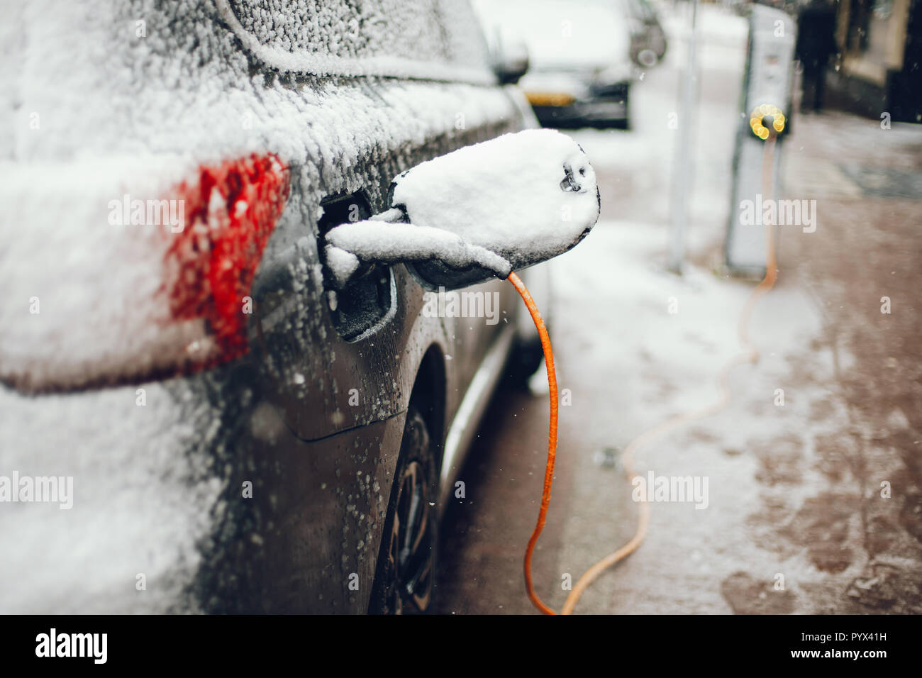 Charging an electric car with the power cable supply Stock Photo