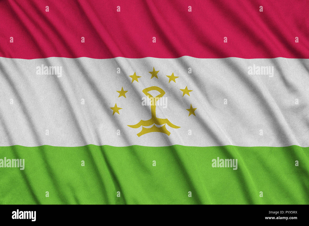 Tajikistan flag  is depicted on a sports cloth fabric with many folds. Sport team waving banner Stock Photo