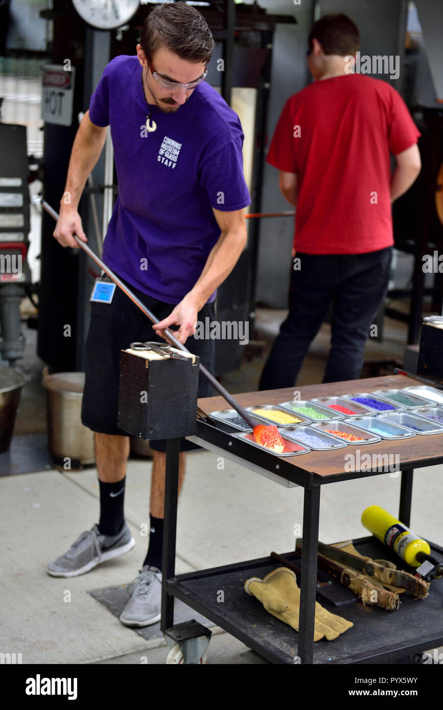 Glass worker demonstrating adding color to glass which will be blown