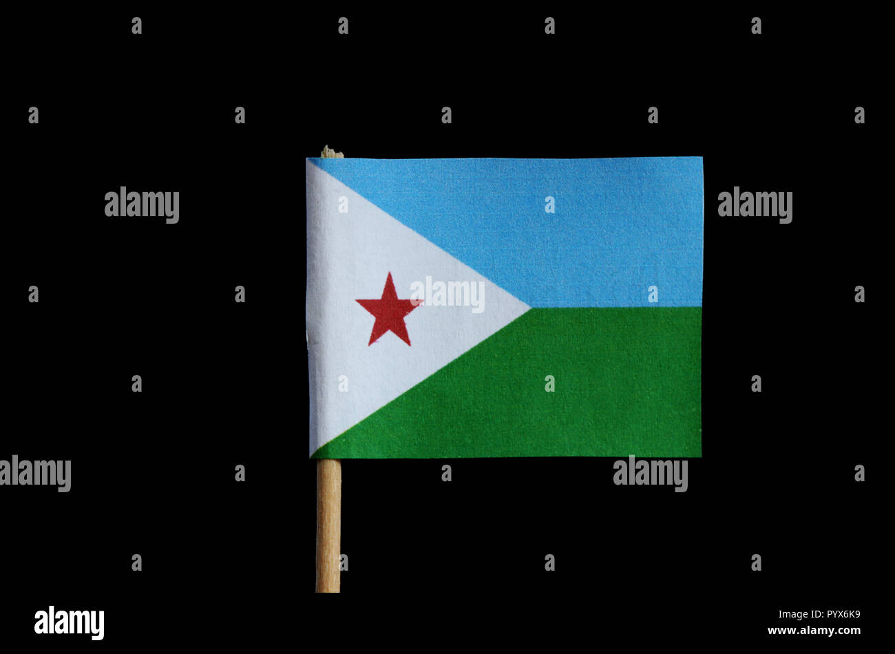 A official national flag of Djibouti on toothpick and black background.  Flag is consist three colours and one red star. Stock Photo