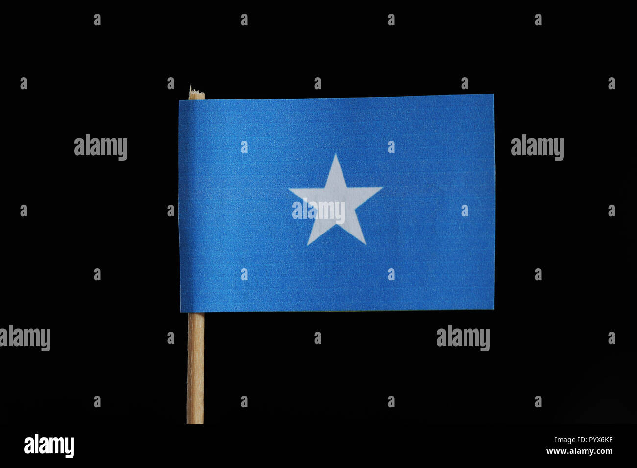 A official flag of Somalia on toothpick on black background. A single white stars on blue field Stock Photo