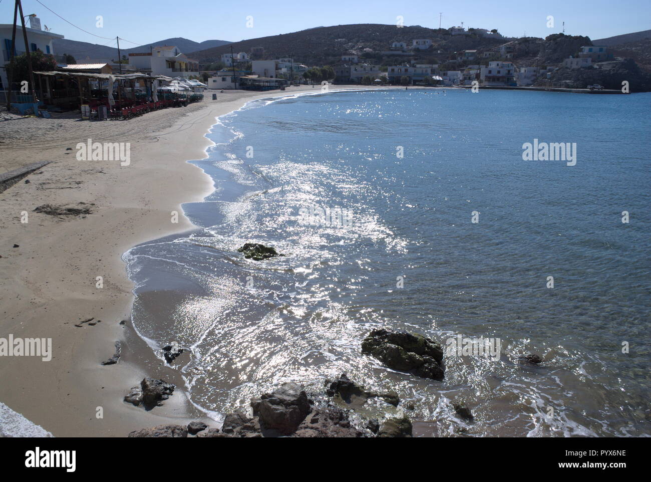 The fine sand beach at the beautiful, small, Greek island of Pserimos.  The sun glints on the tranquil waters of the bay.  Copy space. Stock Photo