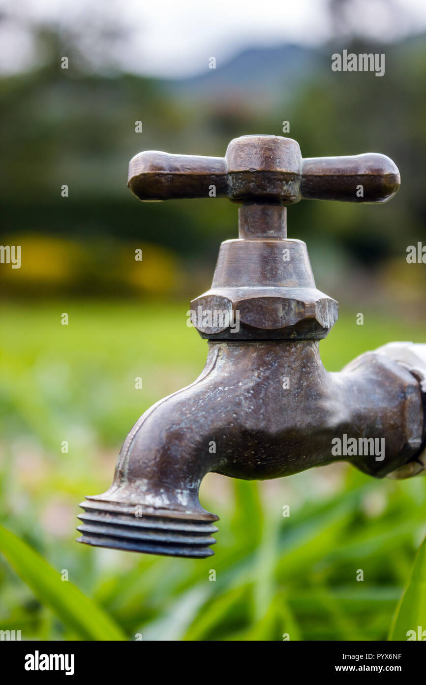 A copper made faucet installed out door to supply water for different purposes like irrigation or to drink. Stock Photo