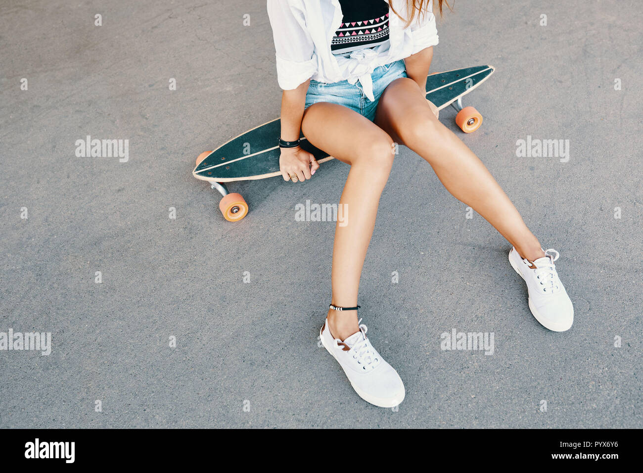Close up of woman legs in white sneakers on longboard Stock Photo - Alamy