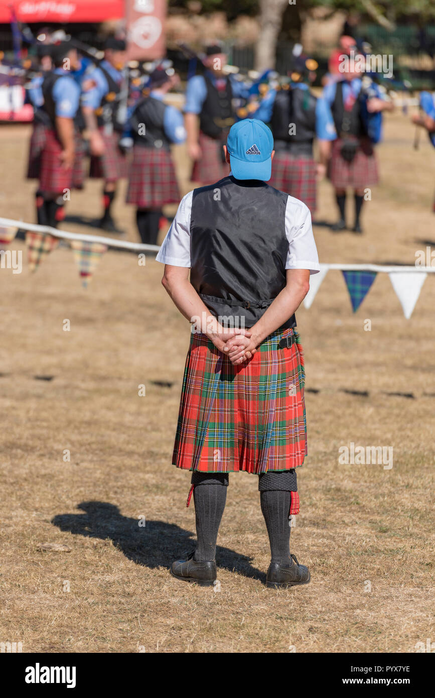 a scotsman wearing a kilt and a baseball cap looking funny and