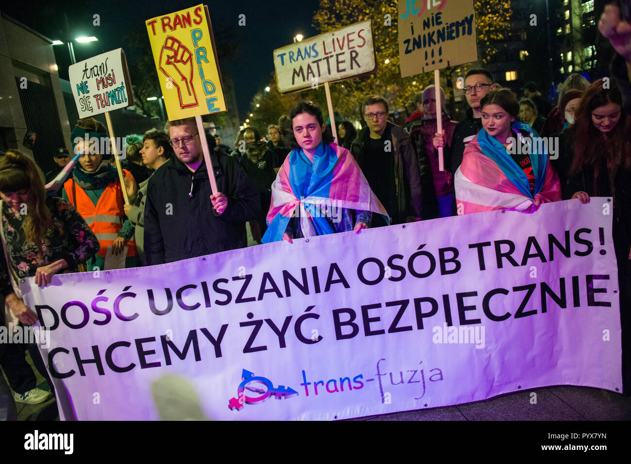 Protesters are seen holding a banner and placards during the protest. Polish LGBTQ organizations protested under the slogan We Will Not Be Erased outside the US embassy while the Activists say the administration of President Donald Trump is trying to deprive the Trans- and intersex persons of legal entity and it is a huge step back in the legal protection of minorities, but above all, a direct threat to the health and life of people who are trans- and intersex. There is no consent'. The New York Times reached a government note in which a suggestion appeared that the 'gender' (cultural part of  Stock Photo