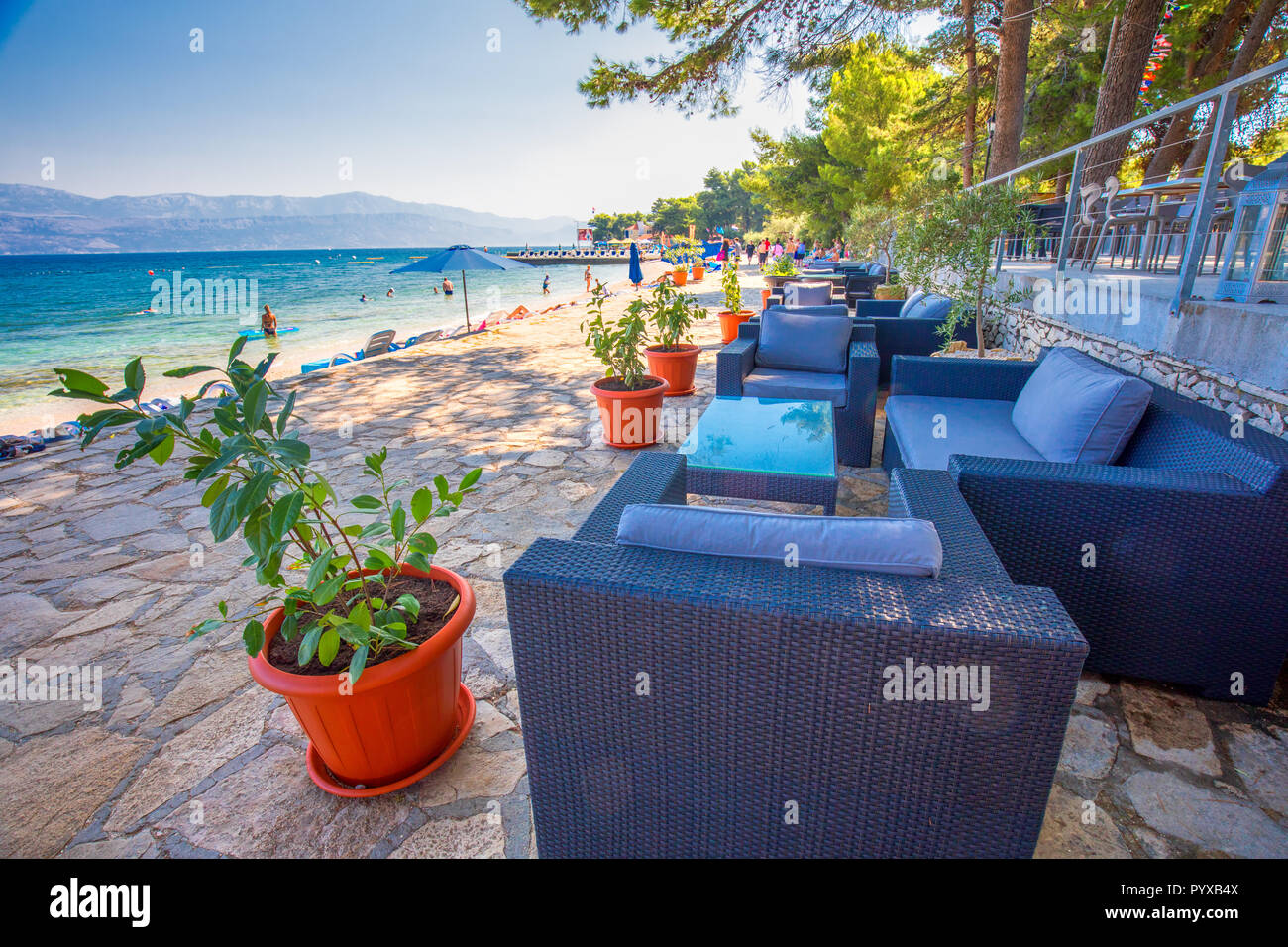 BRAC, CROATIA - August 6, 2018 - Seaside promenade on Brac island with palm trees and turquoise clear ocean water, Supetar, Brac, Croatia Stock Photo