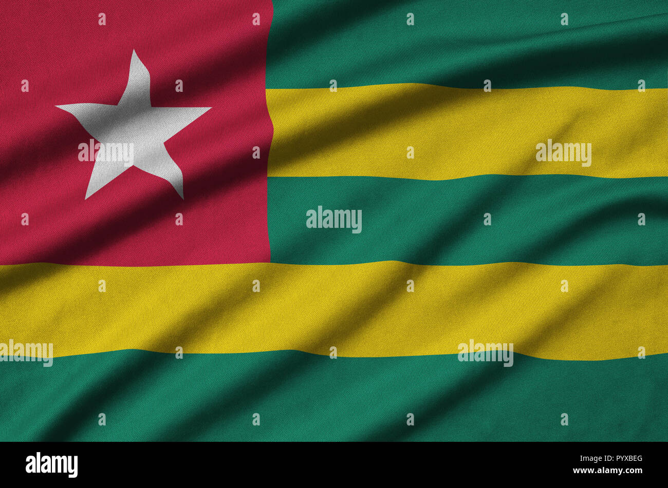 Togo flag is depicted on a sports cloth fabric with many folds. Sport ...