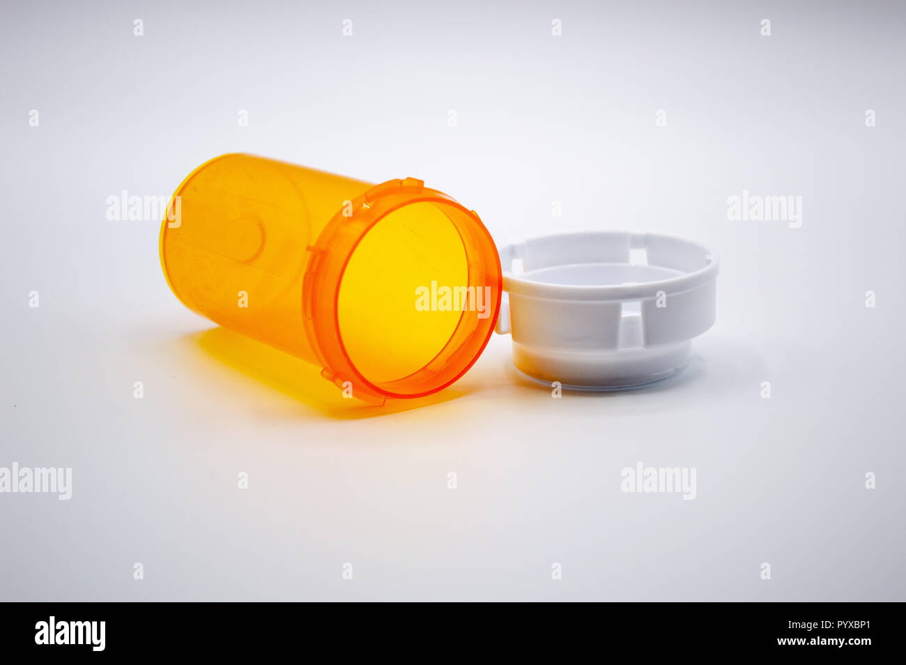 Empty orange medicine bottle with white cap isolated on white background. Stock Photo
