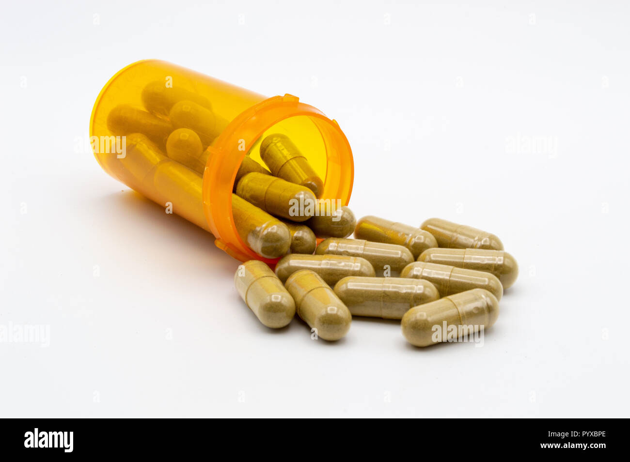 Kratom pill capsules spilling out of pill bottle onto white background Stock Photo
