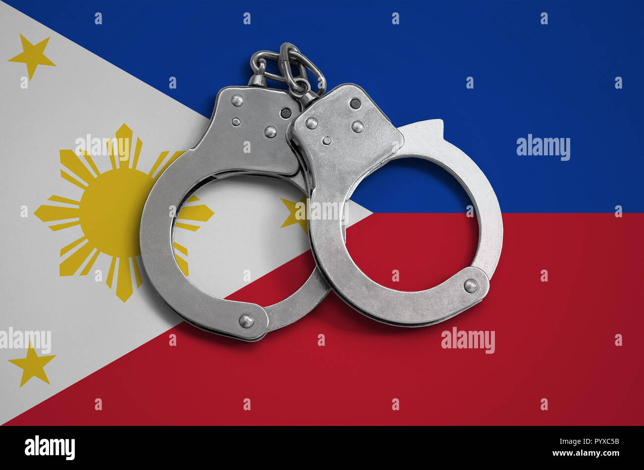 Philippines flag  and police handcuffs. The concept of observance of the law in the country and protection from crime. Stock Photo