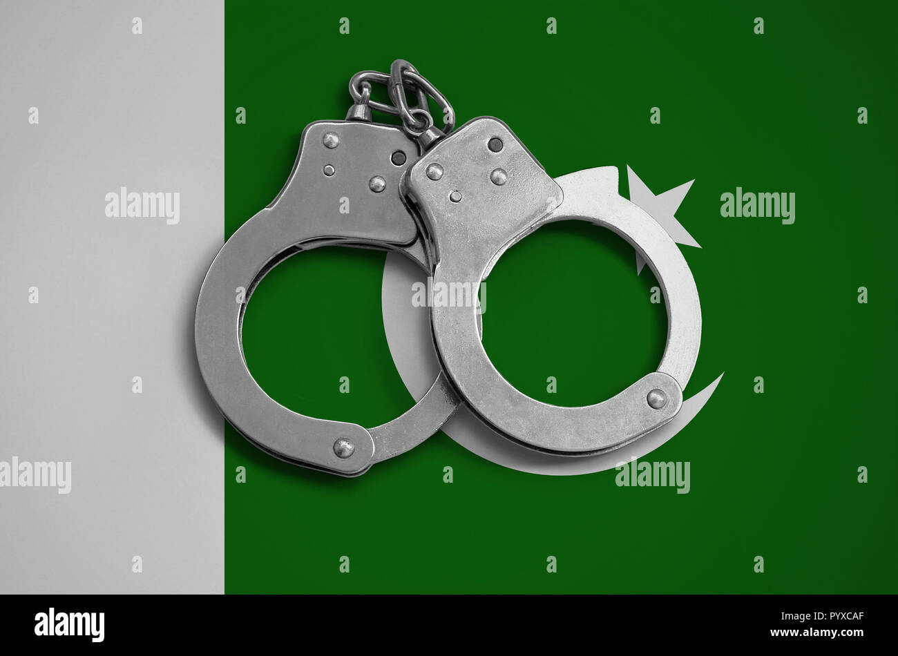 Pakistan flag  and police handcuffs. The concept of observance of the law in the country and protection from crime. Stock Photo