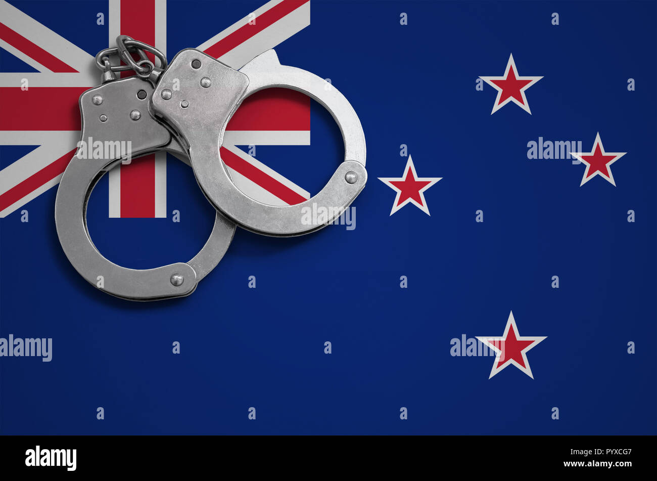 New Zealand flag  and police handcuffs. The concept of crime and offenses in the country. Stock Photo