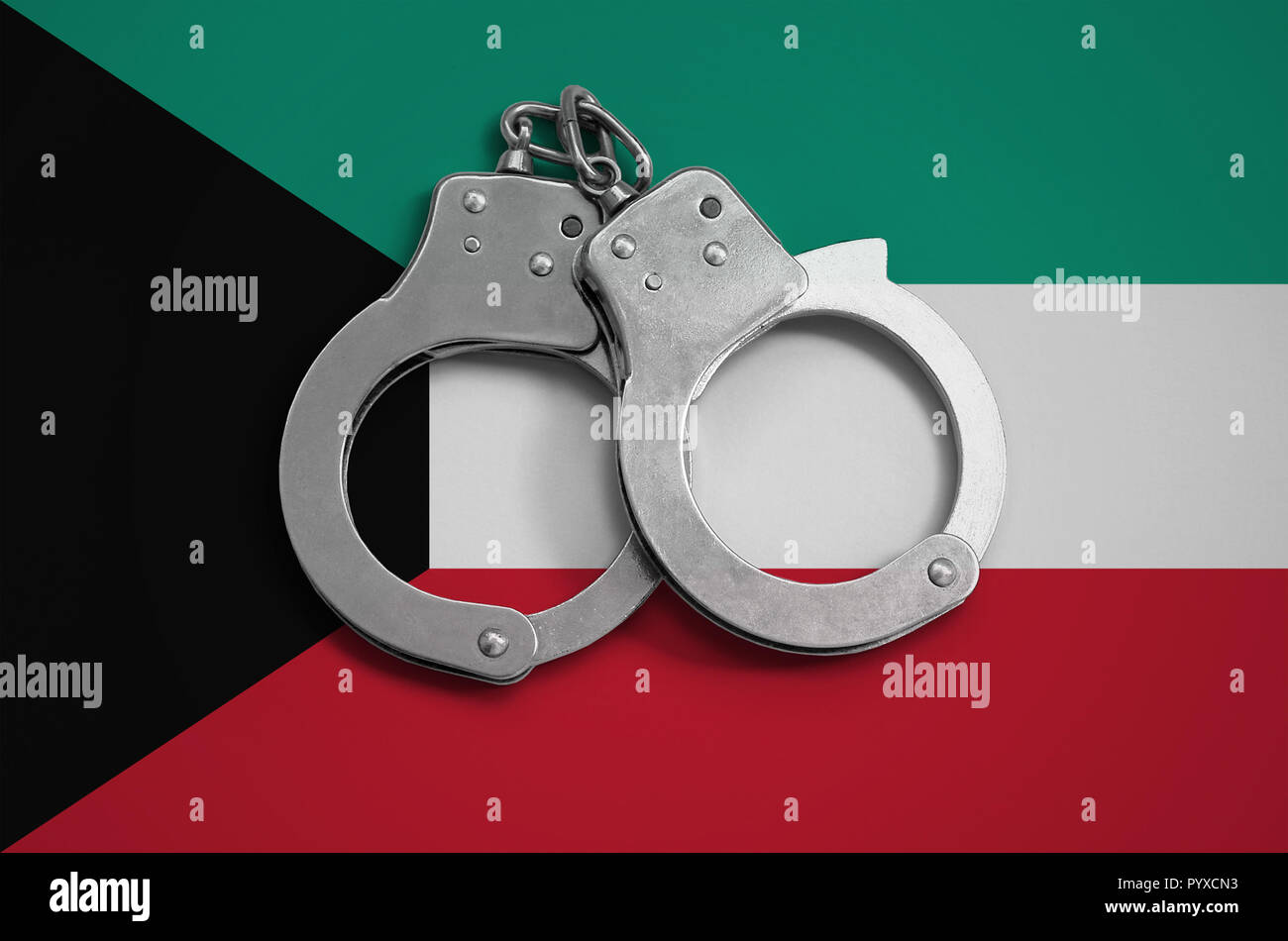 Kuwait flag and police handcuffs. The concept of observance of the law