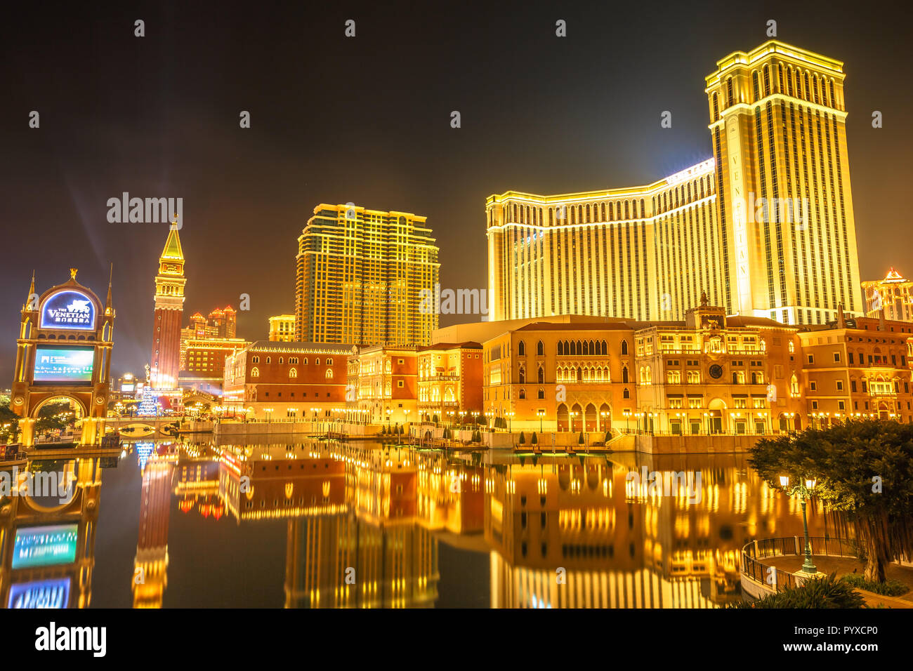 Macau, China - December 9, 2016: Venetian Macao by night, golden colors of this resort and Casino at night seen from Galaxy Cotai Strip. Gambling tourism is Macau's biggest source of revenue. Stock Photo