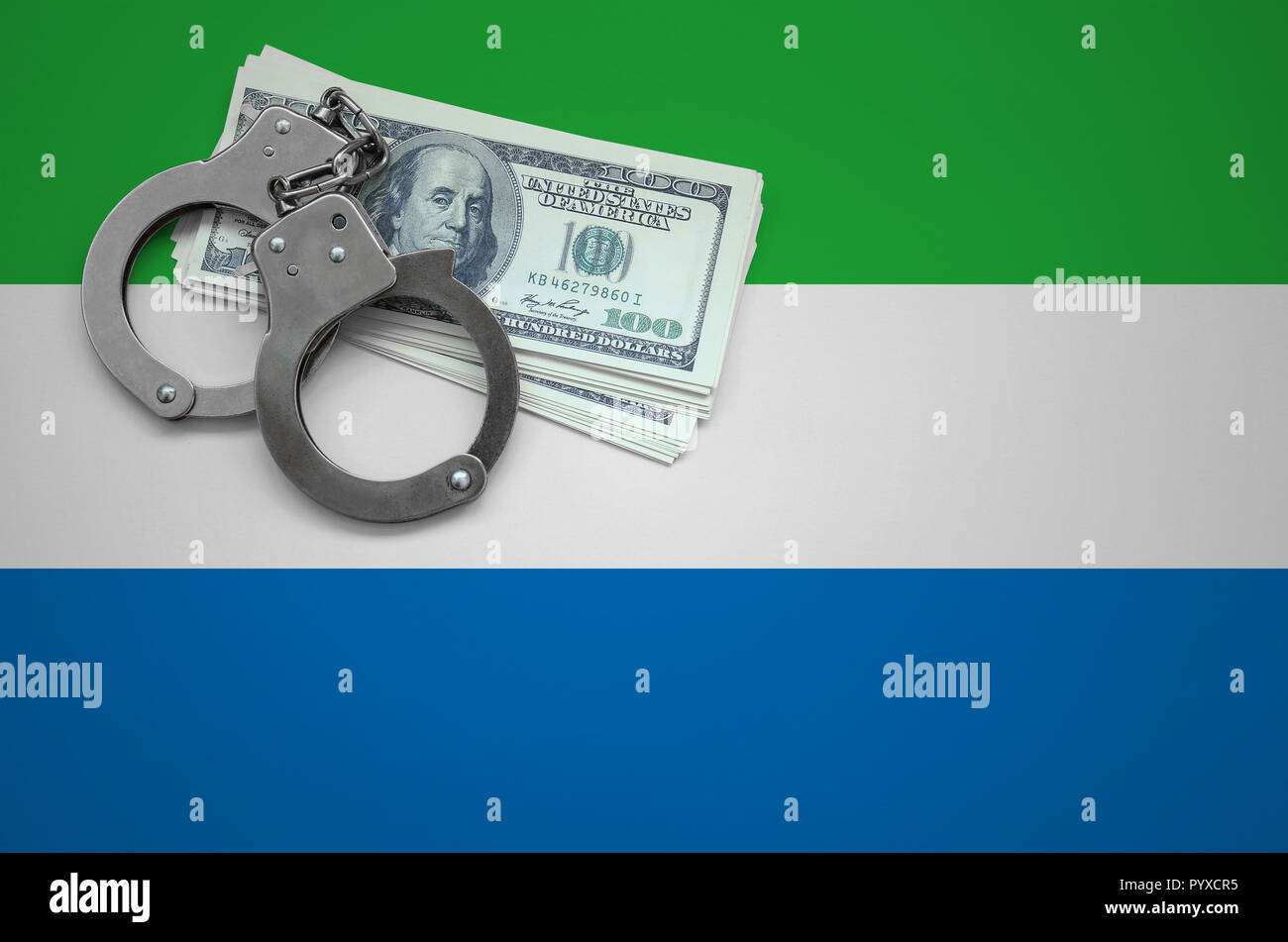 Sierra Leone flag  with handcuffs and a bundle of dollars. The concept of breaking the law and thieves crimes. Stock Photo